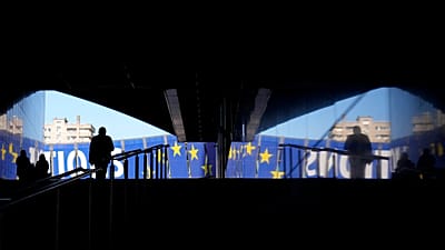 Un uomo cammina verso uno striscione elettorale fuori dal Parlamento europeo a Bruxelles, lunedì 29 aprile 2024. Le elezioni europee si terranno dal 6 al 9 giugno 2024.