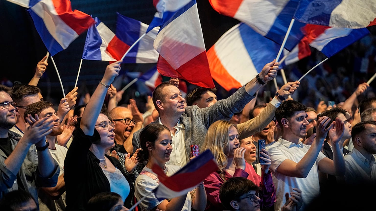 Anhänger der rechtsextremen französischen Nationalen Sammlungsbewegung schwenken am Freitag, den 24. Mai 2024, während einer Versammlung zu den bevorstehenden Europawahlen in Henin-Beaumont, Nordfrankreich, Fahnen. 