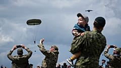 People attend a multinational parachute drop as some 400 British, Belgian, Canadian and US paratroopers jump to commemorate the contribution of airborne forces on D-Day.