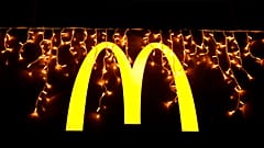 Luces navideñas cuelgan sobre el logotipo fuera de un restaurante McDonald's en Lisboa, el martes 14 de diciembre de 2021. (AP Photo/Armando Franca)