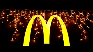Luces navideñas cuelgan sobre el logotipo fuera de un restaurante McDonald's en Lisboa, el martes 14 de diciembre de 2021. (AP Photo/Armando Franca)