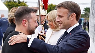 Ukrainian President Volodymyr Zelenskyy, left is greeted by French President Emmanuel Macron, at the international ceremony at Omaha Beach, near Saint-Laurent-sur-Mer.