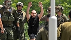 Almog Meir Jan, 21, kidnapped from Israel in a Hamas-led attack on Oct. 7, 2023, raises his hands after arriving by helicopter to the Sheba Medical Center in Ramat Gan, Israel
