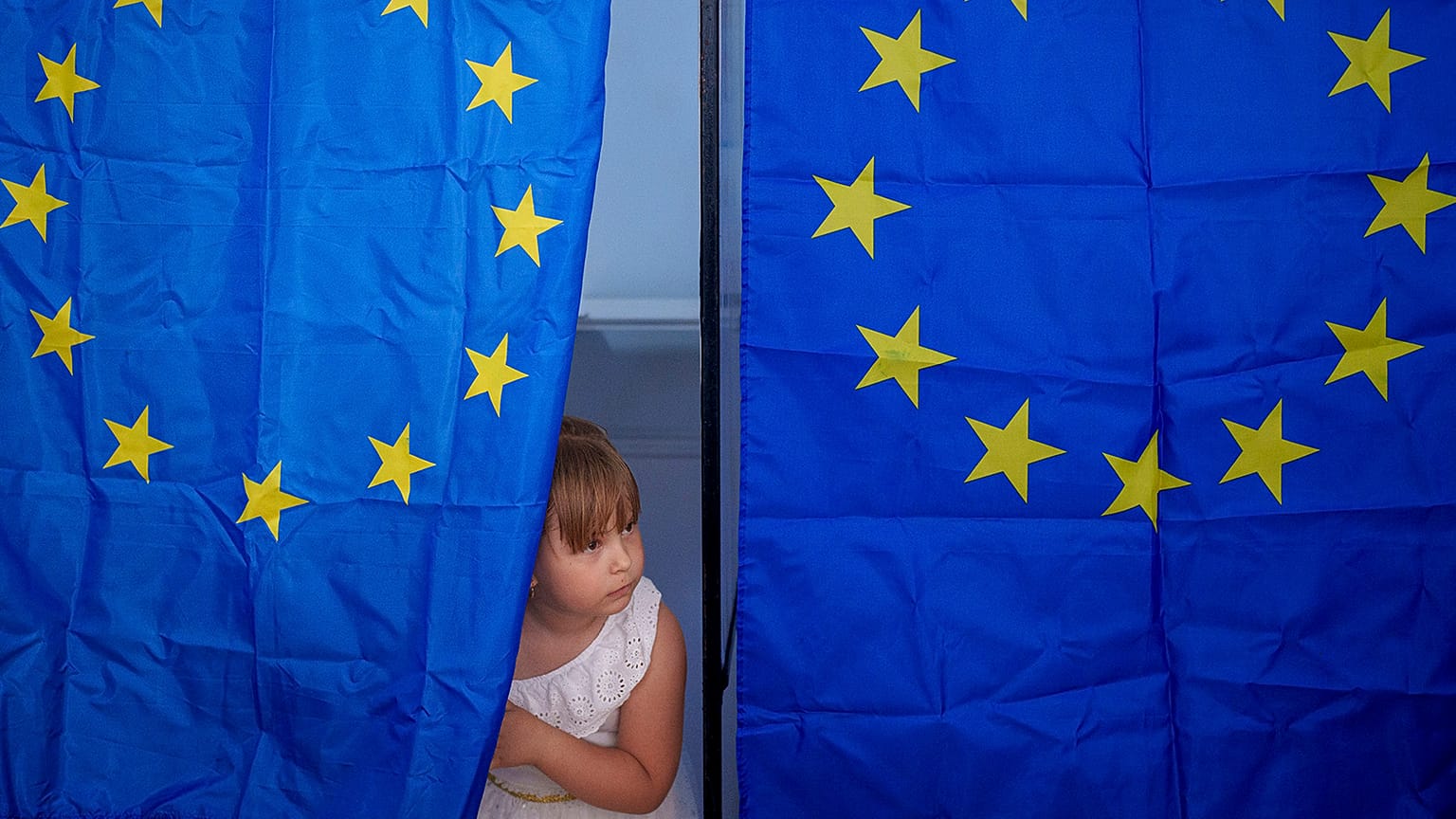 A child peers from a voting cabin during European and local elections in Baleni, 9 June 2024