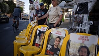 Women hold signs with photographs of hostages who were kidnapped during the Oct. 7 Hamas cross-border attack in Israel