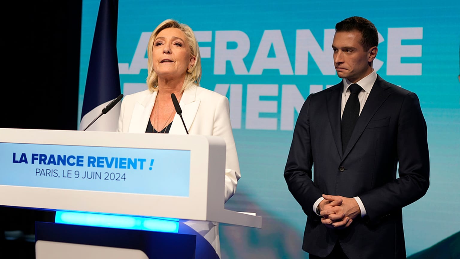 Die französische Rechtsaußenführerin Marine Le Pen spricht, während Jordan Bardella, Vorsitzender der französischen rechtsextremen Nationalversammlung, in der Parteizentrale am Sonntagabend zuhört, 