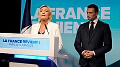 Die französische Rechtsaußenführerin Marine Le Pen spricht, während Jordan Bardella, Vorsitzender der französischen rechtsextremen Nationalversammlung, in der Parteizentrale am Sonntagabend zuhört, 