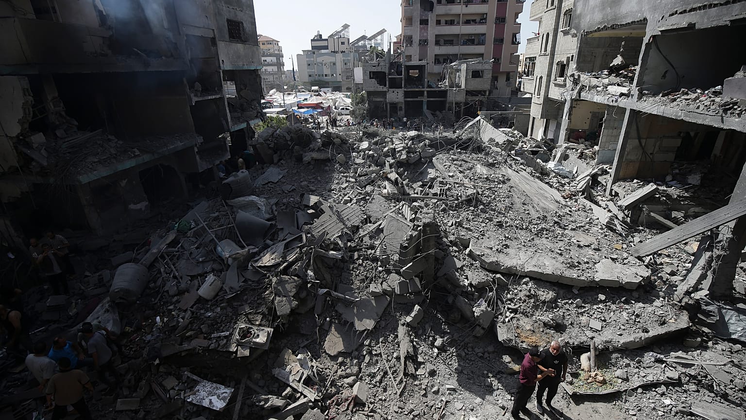 فلسطينيون ينظرون إلى آثار القصف الإسرائيلي في مخيم النصيرات للاجئين، قطاع غزة، في 8 يونيو 2024. 