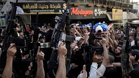 فلسطينيون يرفعون أسلحتهم خلال تشييع جنازة في جنين في الضفة الغربية المحتلة. 2024/06/06