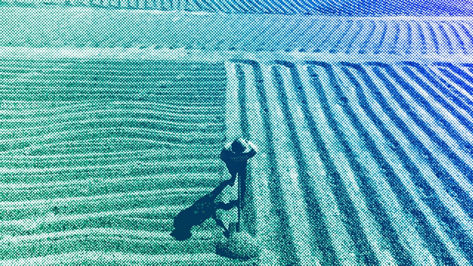 A worker turns coffee beans that are drying in the sun at the Santa Barbara farm in San Juan Alotenango, Guatemala, March 2022