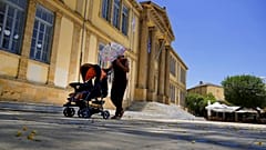  A woman protects herself from the sun with an umbrella as she push a baby in a pushchair during a hot day at Phaneromeni square in central capital Nicosia, 4 June 2024