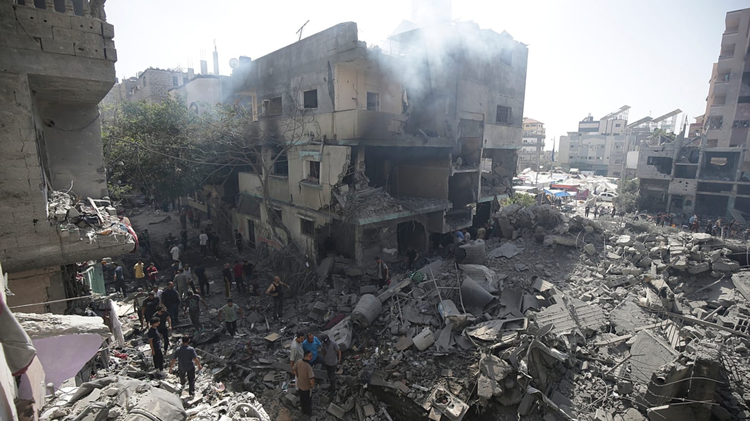 FILE - Palestinians look at the aftermath of the Israeli bombing in Nuseirat refugee camp, Gaza Strip, on June 8, 2024.