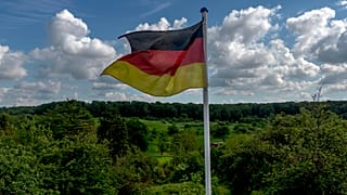 Una bandera nacional alemana ondea en un campo a las afueras de Fráncfort, Alemania, el miércoles 22 de mayo de 2024. (AP Photo/Michael Probst)