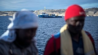 Menekültek. Háttérben a Sea Watch civil szervezet mentőhajója