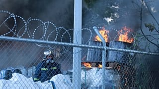 Πυροσβέστης επιχειρεί στην κατάσβεση της πυρκαγιάς σε εργοστάσιο στην Κάτω Κηφισιά