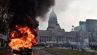 A car burns during clashes between police and protesters outside Congress in Buenos Aires, Argentina, Wednesday, June 12, 2024.