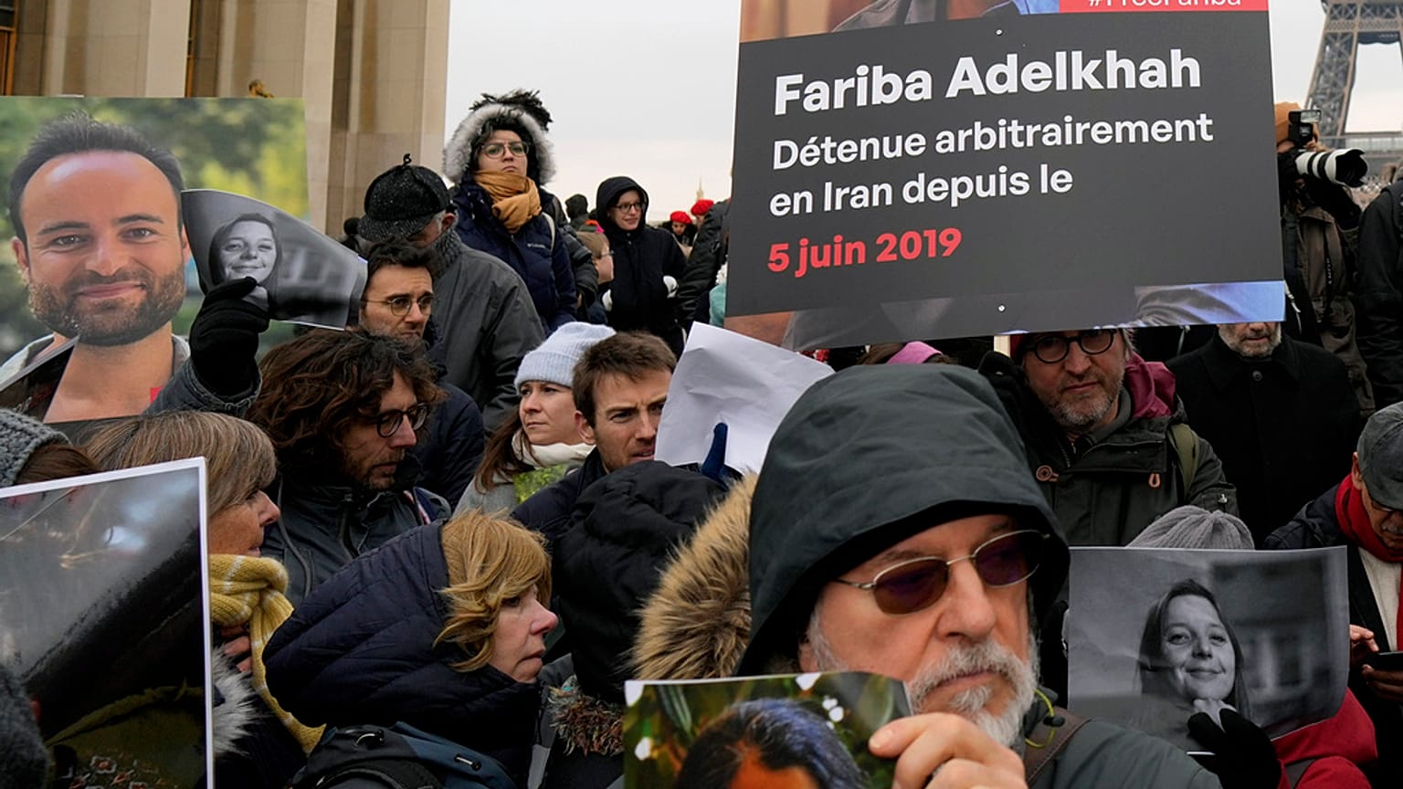 Pessoas seguram retratos de franceses detidos no Irão, incluindo Louis Arnaud, durante um protesto em Paris, sábado, 28 de janeiro de 2023.