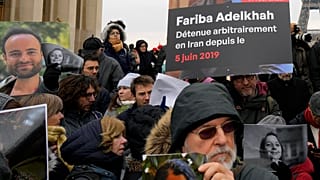 Pessoas seguram retratos de franceses detidos no Irão, incluindo Louis Arnaud, durante um protesto em Paris, sábado, 28 de janeiro de 2023.
