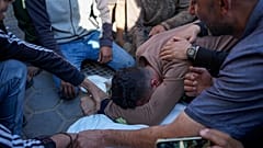فلسطينيون يبكون خلال تشييع جثمان البالغين والأطفال الذين استشهدوا جراء القصف الإسرائيلي على قطاع غزة