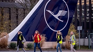 Streikende Flugbegleiter der Lufthansa gehen an einem Flugzeugheck in Frankfurt am Main vorbei, Dienstag, 12. März 2024.