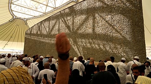 Muslim pilgrims cast stones at pillars in the symbolic stoning of the devil, the last rite of the annual hajj, as it rains in Mina, near the holy city of Mecca, Saudi Arabia.