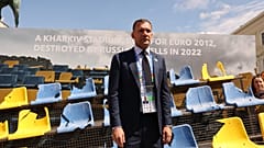 Ukraine Football Association chief Andriy Shevchenko stands in front of the rests of a bombarded Ukrainian football stadium