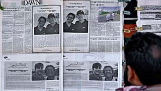A man looks at morning newspapers which published condolence messages for two victims of Titan submersible incident, in Islamabad, 27 June 2023