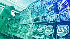 A convenience store customer make a purchase next to a shelf of snacks, in Boston, July 2005