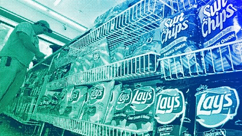 A convenience store customer make a purchase next to a shelf of snacks, in Boston, July 2005