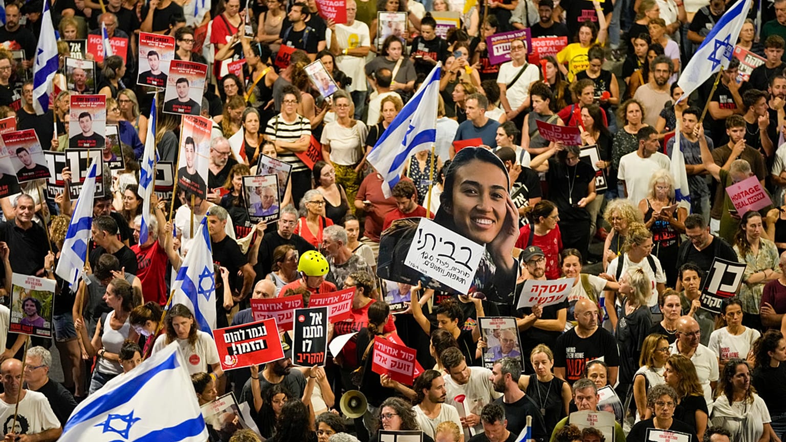 Familiares e apoiantes dos reféns israelitas detidos na Faixa de Gaza pelo grupo militante Hamas seguram cartazes