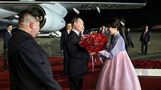 Vlagyimir Putyin üdvözlő csokrot kap a phenjani repülőtéren