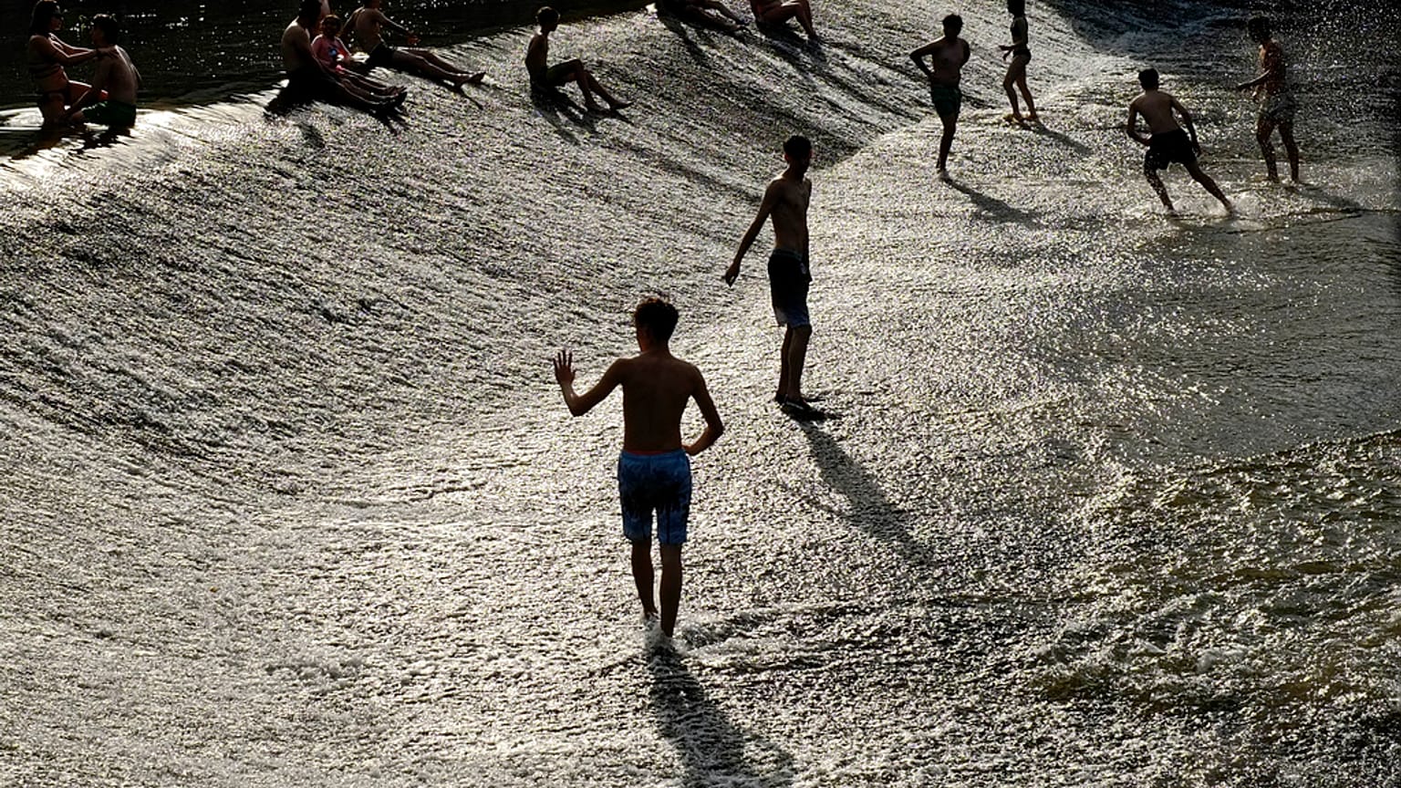 Un grupo de personas se refrescan en Pamplona.