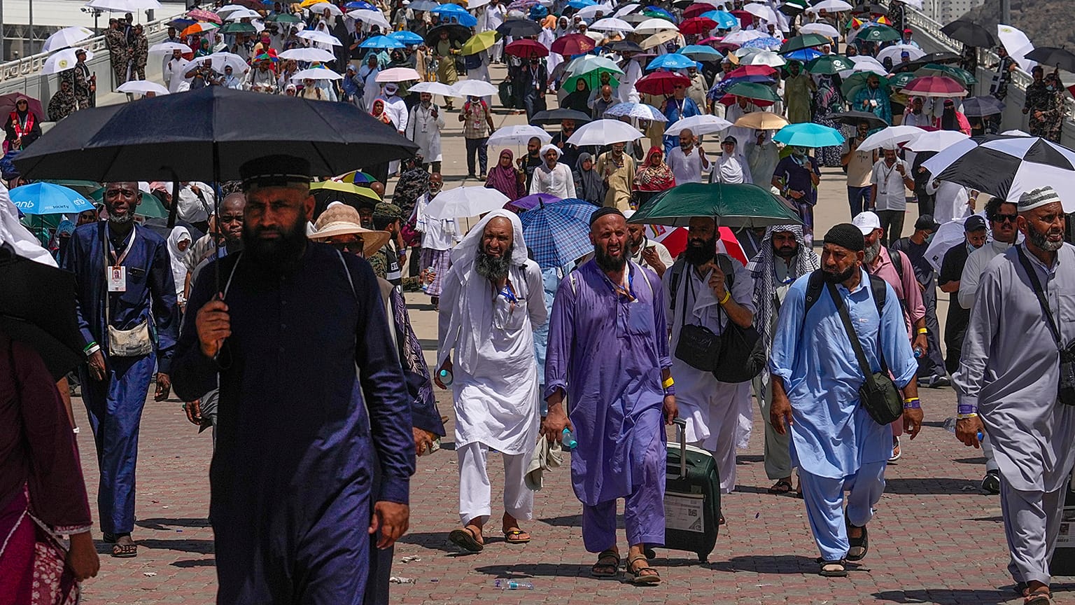Muslim pilgrims use umbrellas to shield themselves from the sun as they arrive to the last rite of the annual hajj, in Mina, 18 June 2024