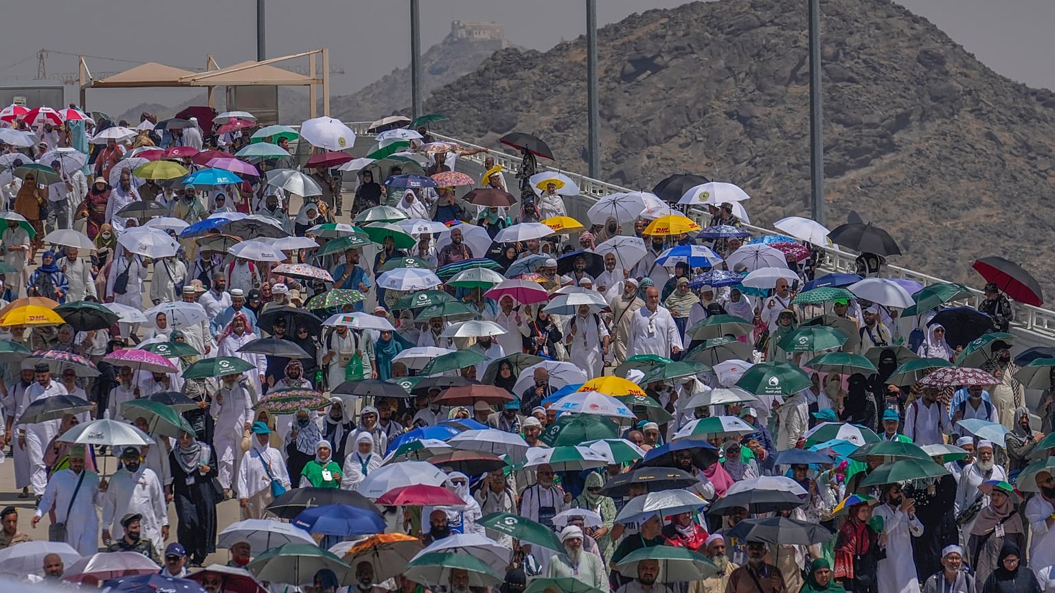 حجاج يحملون مظلات علها تخفف عنهم حرارة الشمس اللاهبة في مدينة مكة 