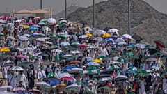 حجاج يحملون مظلات علها تخفف عنهم حرارة الشمس اللاهبة في مدينة مكة 
