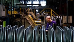 A steel worker manufactures 155 mm M795 artillery projectiles.