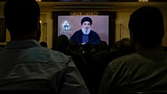 Menschen schauen eine Rede von Hisbollah-Anführer Hassan Nasrallah während einer Gedenkfeier für den verstorbenen Kommandanten am Mittwoch, den 19. Juni 2024.