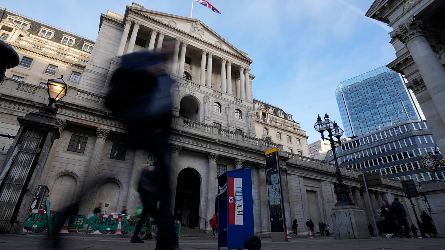 People walk past the Bank of England in London