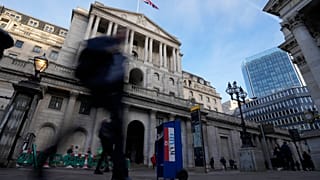 People walk past the Bank of England in London