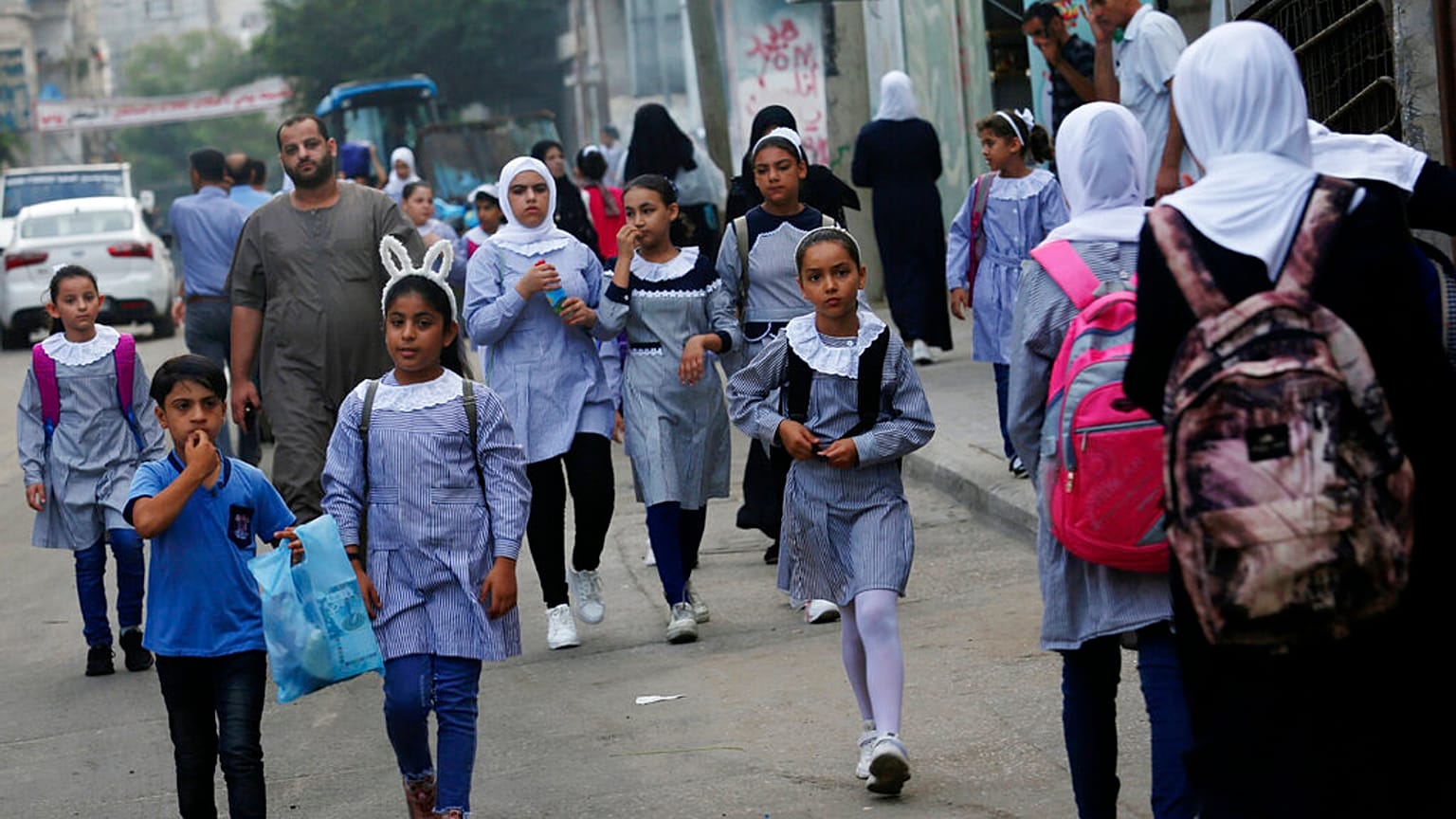 طلاب يسيرون إلى المدرسة الابتدائية في مخيم الشاطئ للاجئين في مدينة غزة