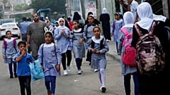 طلاب يسيرون إلى المدرسة الابتدائية في مخيم الشاطئ للاجئين في مدينة غزة