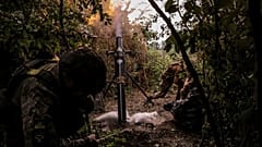 Украинские солдаты ведут огонь из 120-мм миномета по российским позициям на линии фронта в районе Часова Яра в Донецкой области.