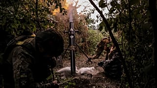 Украинские солдаты ведут огонь из 120-мм миномета по российским позициям на линии фронта в районе Часова Яра в Донецкой области.