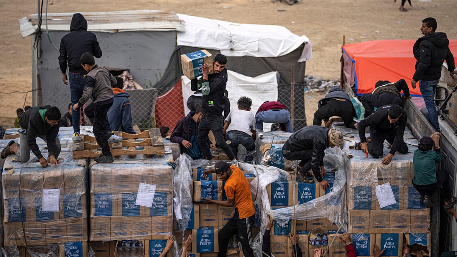 I palestinesi saccheggiano un camion di aiuti umanitari mentre attraversava la Striscia di Gaza a Rafah, domenica 17 dicembre 2023.