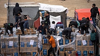 I palestinesi saccheggiano un camion di aiuti umanitari mentre attraversava la Striscia di Gaza a Rafah, domenica 17 dicembre 2023.