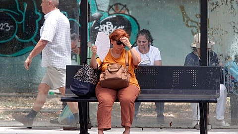 Uma mulher tenta refrescar-se enquanto espera por um autocarro num dia quente em Skopje, na Macedónia do Norte