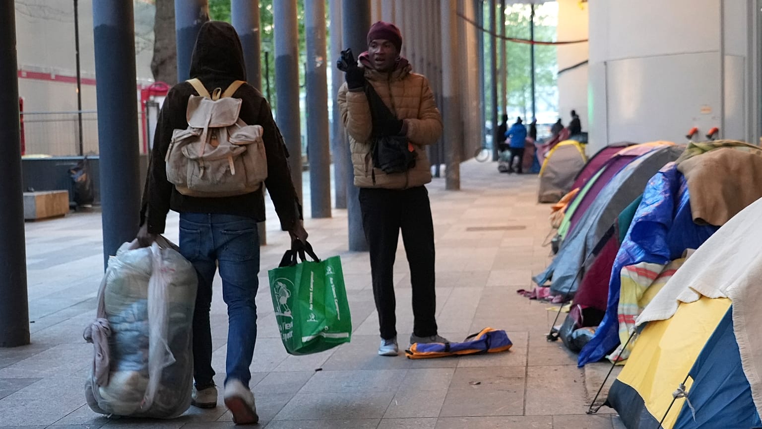 Migrantes abandonan un campamento improvisado tras ser desalojados por agentes de policía, la madrugada del martes 23 de abril de 2024 en París.