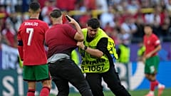 Steward catches a pitch invader that ran to Portugal's Cristiano Ronaldo during a Group F match between Turkey and Portugal at the Euro 2024 soccer tournament in Dortmund.