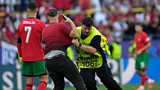 Steward catches a pitch invader that ran to Portugal's Cristiano Ronaldo during a Group F match between Turkey and Portugal at the Euro 2024 soccer tournament in Dortmund.