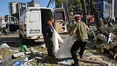 Gemeindearbeiter tragen eine Leiche, nachdem ein Wohnhaus von einer russischen Luftbombe getroffen wurde, Charkiw, Ukraine, Samstag, 22. Juni 2024.